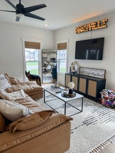 a living room filled with furniture and a flat screen tv mounted to the side of a wall