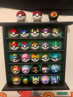 a display case filled with lots of different colored pokeballs on top of each other