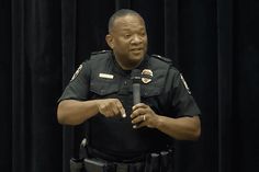 a police officer standing in front of a microphone