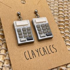 a pair of calculator earrings sitting on top of a piece of cardboard