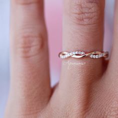 a woman's hand with a wedding band on it and a diamond ring in the middle