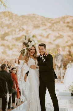 a bride and groom standing in front of an outdoor ceremony