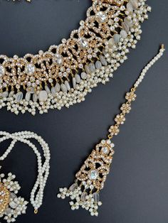 Discover the epitome of elegance with our Polki Choker Set, a celebration of exquisite craftsmanship and timeless allure. This set is a fusion of cultural beauty, featuring not one, but two necklaces, a stunning tikka, and a pair of earrings, all adorned with delicate polki and intricate kundan work. Pastel Perfection and Subtle Gray/Dusty Blue Envelop yourself in the soft embrace of pastel hues and graceful gray/dusty blue accents. The choker set boasts a delicate balance of colors, reflecting Elegant Hand Set Tikka For Festive Occasions, Elegant Chandbali Bridal Necklace Hand Set, Elegant Tikka With Intricate Design For Festive Occasions, Elegant Festive Tikka With Stone Work, Elegant Meenakari Tikka For Festivals, Eid Celebration Stone Work Tikka, Elegant Hand-set Kundan Necklace For Festivals, Elegant Kundan Necklace With Stone Work For Celebration, Elegant Kundan Tikka For Festivals