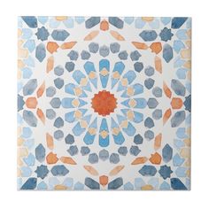 an artistic tile design in blue, orange and white with the center star surrounded by smaller shapes