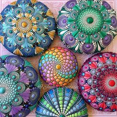 four painted rocks sitting on top of a table