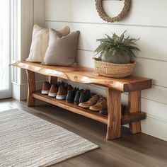 a wooden bench with shoes on it next to a potted plant and window sill