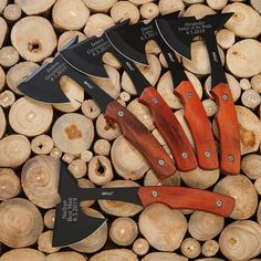 five knives sitting on top of a pile of cut wood next to eachother