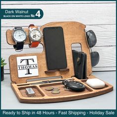 a wooden desk organizer with cell phone, wallet and other personal items on it in front of a white background