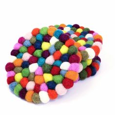 multicolored pom - poms are scattered on top of the white surface