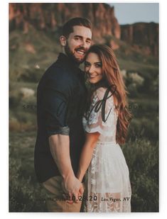 a man and woman standing next to each other in front of a rocky mountain range