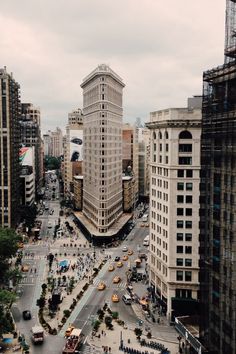 an aerial view of a busy city street with tall buildings and cars on the road