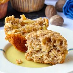 two muffins on a white plate with butter and walnuts in the background