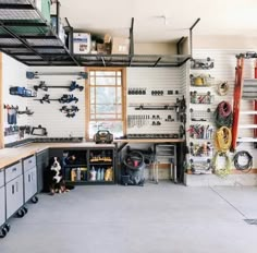 a garage with lots of tools on the wall and shelves filled with various items in it