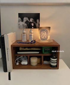 a wooden shelf with various items on top of it next to a book and lamp