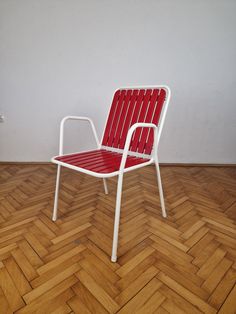 a red and white chair sitting on top of a hard wood floor