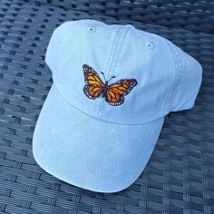 a blue hat with a butterfly embroidered on it