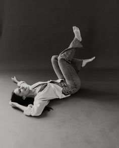 a man falling off his skateboard on the ground in front of a black and white background