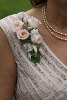 a close up of a woman wearing a necklace with flowers on it