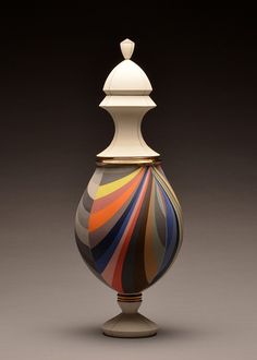 a colorful striped vase sitting on top of a table