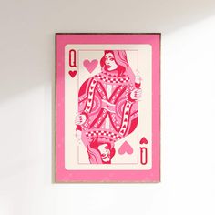 a pink and white ace playing card hanging on the wall with two hearts around it