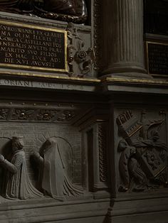 a statue in the middle of a wall with writing on it