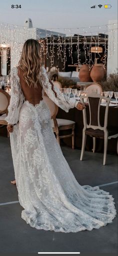 the back of a woman's wedding dress, with long sleeves and open shoulders