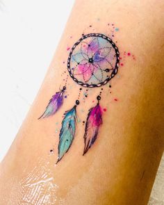 a woman's leg with a tattoo that has a colorful dream catcher on it