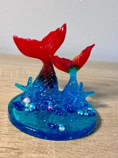 a glass figurine is sitting on top of a wooden table with water and stars