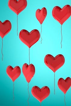 many red heart balloons floating in the air with strings attached to them, on a blue background