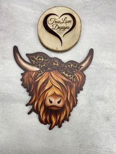 a wooden bull with a leopard print on it's head is next to a sign that says true love designs