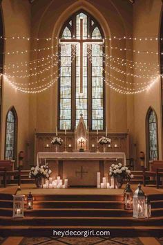 the inside of a church with candles and flowers on the alter, surrounded by lights