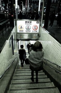 two people walking up some stairs at night