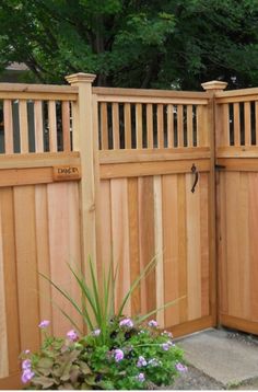 a wooden fence with flowers in the foreground