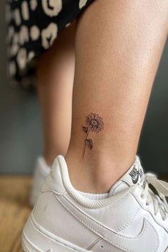 a small daisy tattoo on the ankle