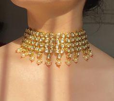 Adorn your beautiful personality with this exquisitely designed and handcrafted high quality kundan choker necklace and earrings set . Pair it up with your silks and satins and shine like a glowing star at the next event!Necklace weight 120 GM's Length of the metal part 7 inches with an adjustable zari thread at the backWidth from top to bottom 2.5 inchesEarrings length 2.2 inchesWeight 24 GM'sColour:Emerald Green******************************************Product Care: Avoid spraying perfume or d Heavy Kundan Choker Necklace, Kundan Choker Necklace For Diwali, Heavy Kundan Choker Necklace For Festive Season, Heavy Kundan Choker For Festive Occasions, Festive Kundan Bridal Choker Necklace, Diwali Kundan Choker Necklace, Diwali Kundan Choker With Tilla, Kundan Choker Necklace For Celebration, Festive Kundan Cutdana Choker Necklace