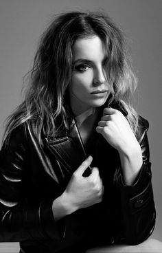 a black and white photo of a woman in a leather jacket posing for the camera