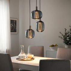 three lights hanging over a dining room table