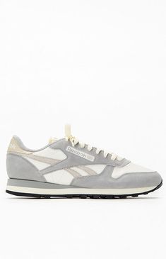 The Reebok Classic Leather Shoes in gray pay homage to their 1983 debut as running shoes turned fashion icons. This version blends old-school charm with a blend of nylon and suede on the upper, complemented by touches of color and an asymmetrical logo for a modern twist on a legendary design.PLEASE NOTE: This shoe is offered in Men's sizes; please consult the Size Chart above - the conversion is a size and a half smaller for women. For example, a woman who is a size 7.5 should order a size 6 in Men's.Leather and suede upperTextile liningLace closureEVA midsoleRubber outsole Reebok Mens Gray Classic Leather Shoes size 10 Gray Leather Sneakers For Running Errands, Vintage Gray Sneakers With Round Toe, Retro Gray Low-top Sneakers, Retro Gray Sneakers With Round Toe, Rebook Classic, Beige Skin, Reebok Classic Leather, Charm School, Shoes Size 6