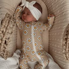 a baby is laying in a crib wearing a white headband