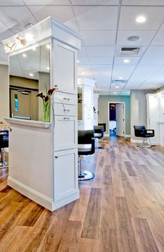 the interior of a hair salon with chairs and mirrors