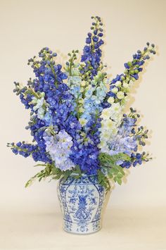 a blue and white vase filled with lots of flowers