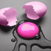 two pink eggs in the shape of a person's head on a gray surface