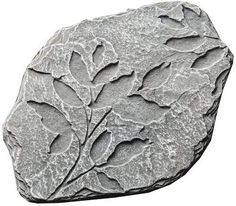 a rock with leaves on it is shown in this image, the stone has been carved into