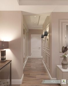 an empty hallway is shown with beige walls and wood flooring, along with two lamps on either side of the hall