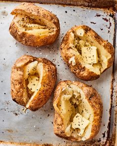 four pieces of bread that have been baked with cheese and herbs in them on a baking sheet