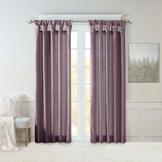 a living room with white carpet and purple curtains