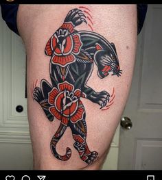 a tattoo on the leg of a man with an animal in red and black colors