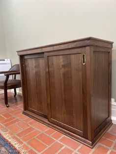 a wooden cabinet sitting on top of a red brick floor