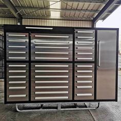 a large metal cabinet with many drawers on it's sides and doors open in front of a building