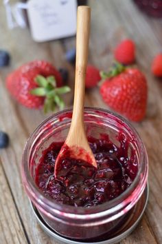 a wooden spoon in a jar filled with blueberry jam